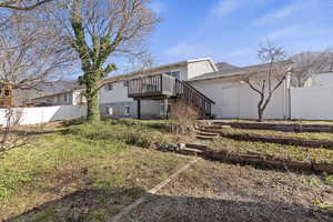 Back of property with stairway and a deck