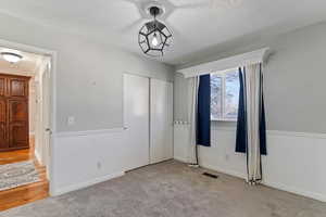 Unfurnished bedroom with light colored carpet, a textured ceiling, and a closet