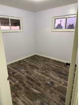 Empty room featuring dark wood-style flooring and baseboards