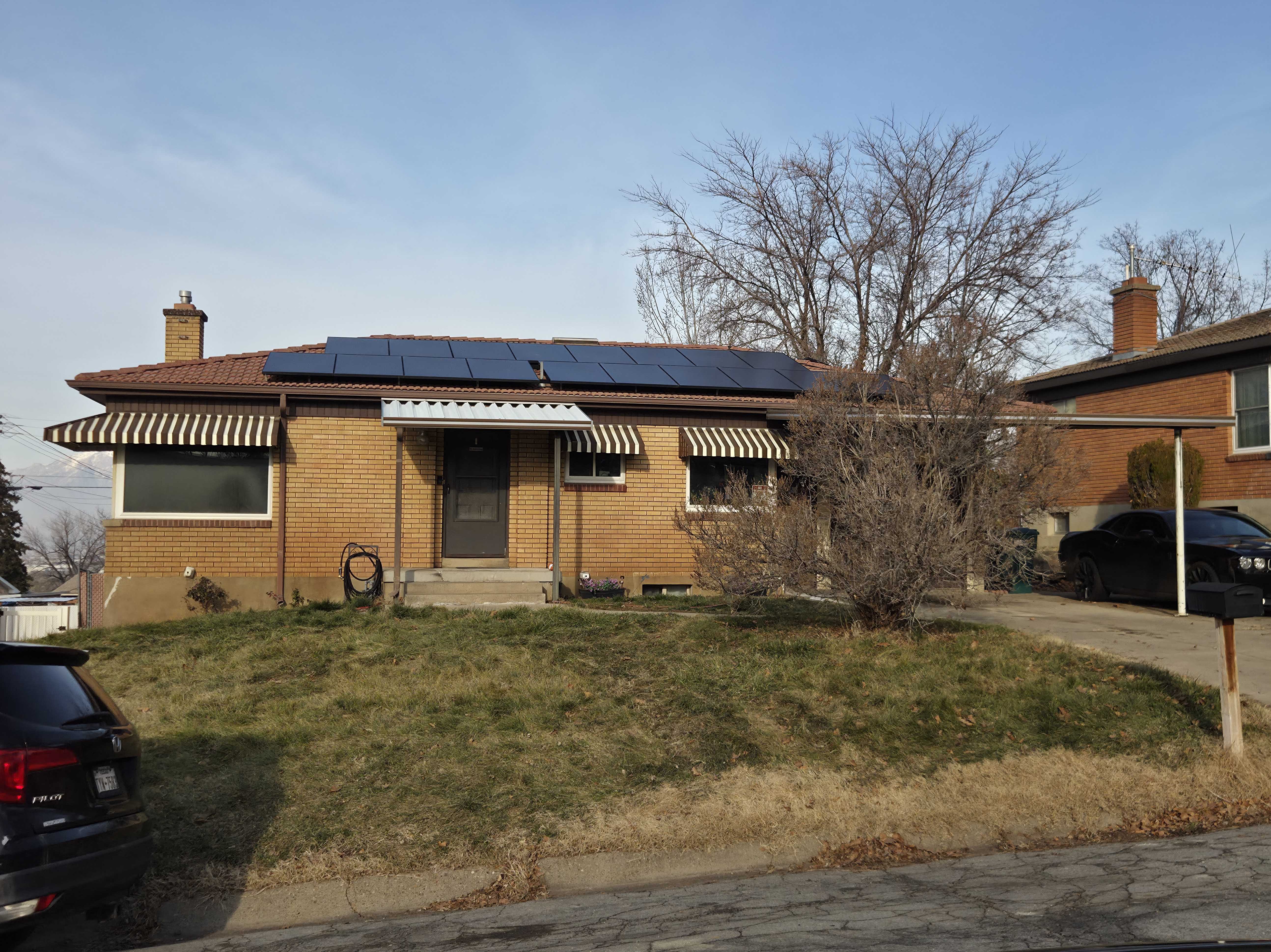 Single story home with a front lawn, brick siding, and a chimney