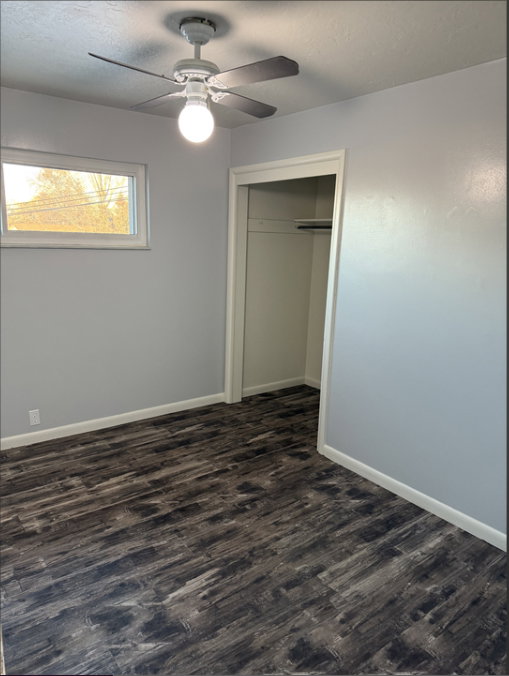 Unfurnished bedroom featuring a ceiling fan, new Lifeproof dark wood-type flooring, a closet, and a textured ceiling
