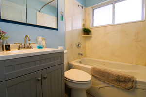 Full bath with vanity and a jetted tub and shower combination