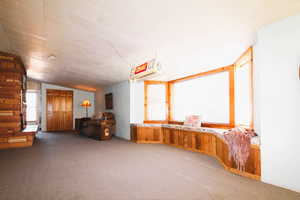 Carpeted family room with a large fireplace and a brick wall, a fireplace and window seat