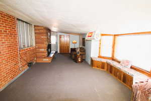 Carpeted family room with a large fireplace and a brick wall, a fireplace and window seat