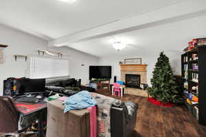 Living area featuring a tiled fireplace and dark wood finished floors