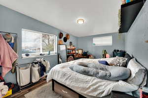 Bedroom featuring wood finished floors and vaulted ceiling
