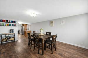 Dining area featuring dark wood-style flooring and a textured ceiling