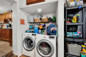 Laundry room with washing machine and dryer and stone tile floors