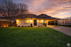 View of front of home featuring a carport, concrete driveway, a porch, and a front yard
