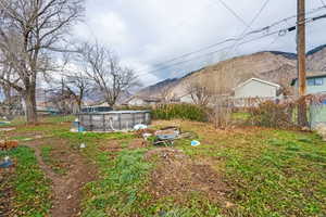 View of yard with a mountain view, an exterior structure, and an outdoor structure