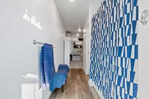 Hallway with wood finished floors and recessed lighting