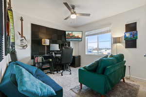 Carpeted office with ceiling fan and baseboards