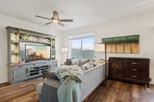 Living room featuring ceiling fan and dark wood finished floors