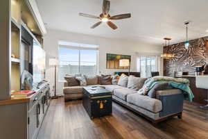 Living area with dark wood finished floors and ceiling fan