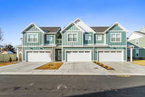Craftsman-style house featuring board and batten siding, driveway, and a garage