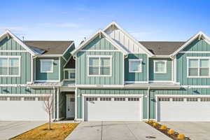Craftsman-style home featuring board and batten siding, concrete driveway, and a shingled roof