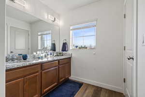 Bathroom featuring double vanity and dark wood-style flooring