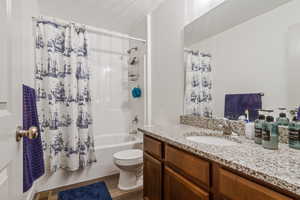 Bathroom with shower / bath combo, dark wood finished floors, and vanity