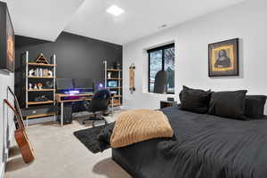 Carpeted bedroom with an office area