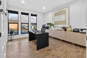 Office with light wood finished floors and recessed lighting