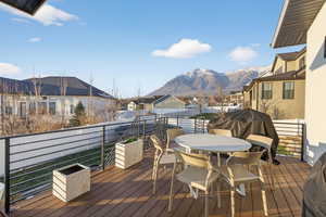 Deck with outdoor dining space, a mountain view, and a residential view
