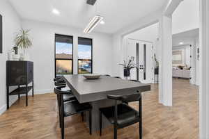 Dining space featuring french doors, light wood-style floors, and recessed lighting