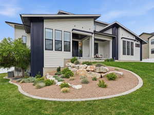 View of front of house featuring a front lawn and covered porch