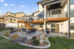 Rear view of house featuring a patio area, stucco siding, and stairs