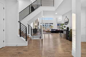 Entryway featuring stairs, wood finished floors, a high ceiling, and recessed lighting