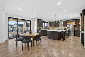 Dining area with light wood-type flooring and recessed lighting