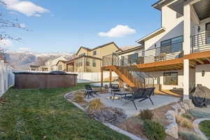 Fenced backyard with a patio, stairs, and a deck with mountain view