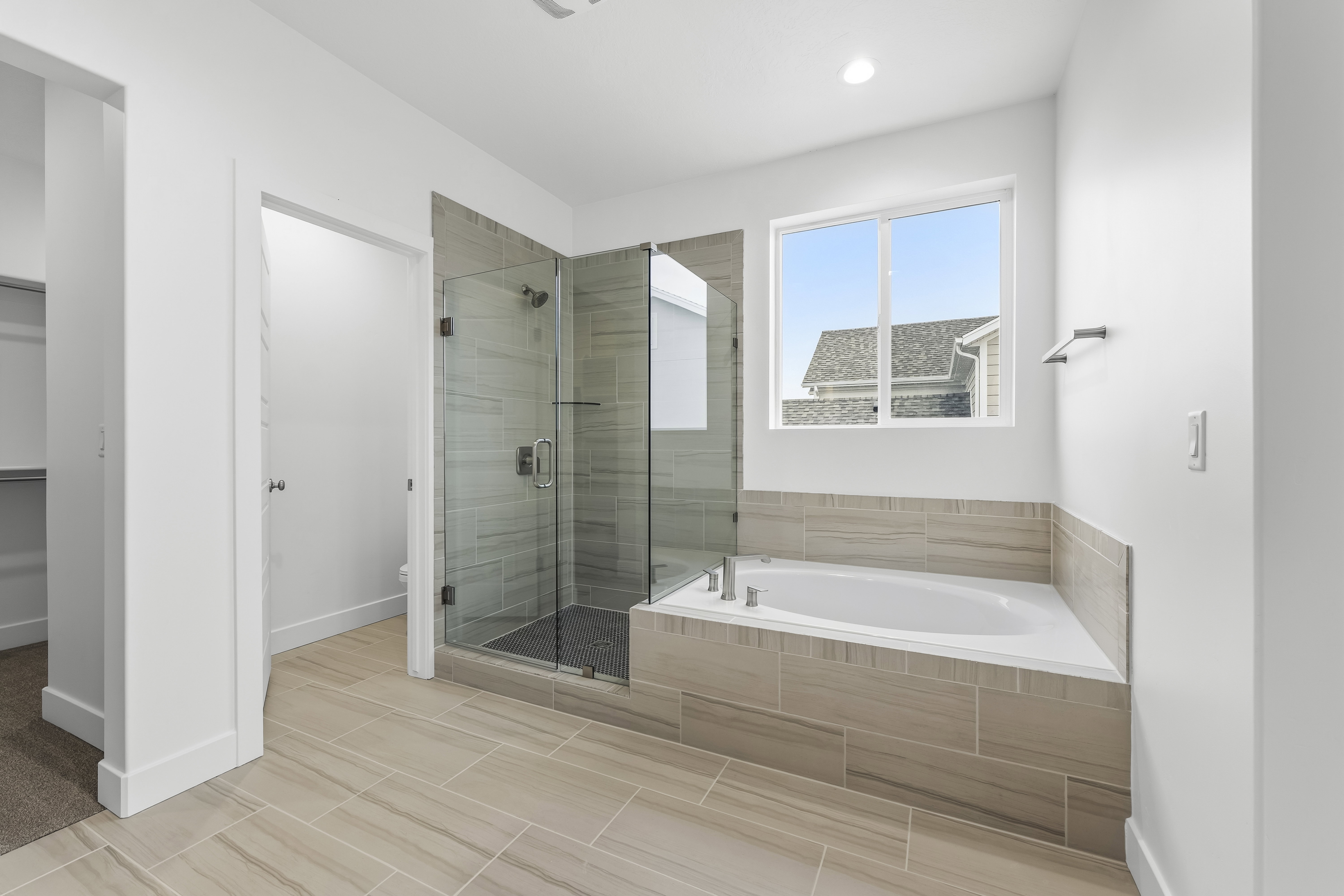 Full bath featuring a garden tub, a stall shower, and a spacious closet