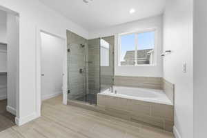 Full bath featuring a garden tub, a stall shower, and a spacious closet