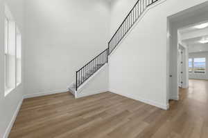 Staircase with wood finished floors and baseboards