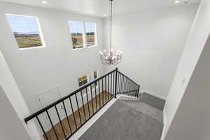 Stairway with recessed lighting, a chandelier, and carpet flooring