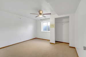 Unfurnished bedroom featuring a closet, light carpet, and ceiling fan