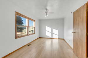 Empty room featuring light wood-type flooring and ceiling fan