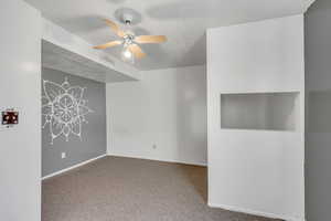Carpeted empty room with baseboards and ceiling fan