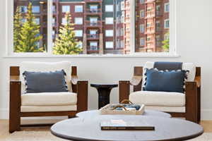 Bright interiors featuring a large window with white trim, wood-finish flooring, and crisp white walls