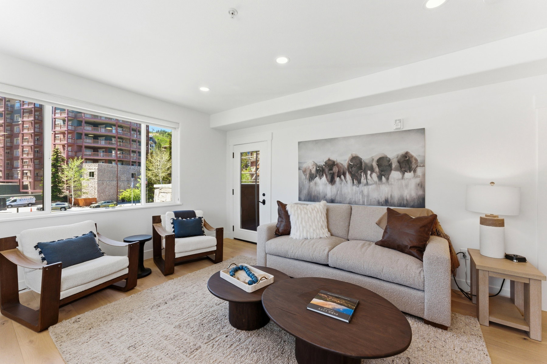 Light wood-finish flooring complements the neutral wall tones of this living space
