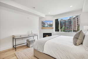 Bedroom featuring wood finished floors, a fireplace, and recessed lighting