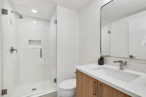 Bathroom with vanity, a shower stall, and recessed lighting