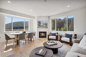 Living area with a tiled fireplace, plenty of natural light, recessed lighting, and light wood-type flooring