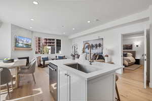 Kitchen featuring open floor plan, light stone countertops, white cabinetry, light wood-style floors, and recessed lighting
