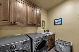 Washroom featuring washing machine and clothes dryer and cabinet space