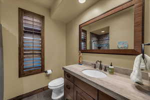 Full bath featuring vanity, a shower with curtain, and dark tile patterned flooring