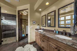 Full bathroom featuring double vanity, a stall shower, recessed lighting, a walk in closet, and dark tile patterned floors