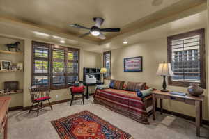 Living area featuring a ceiling fan, plenty of natural light, a tray ceiling, light carpet, and recessed lighting