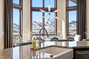 Kitchen view of dark stone countertops and a chandelier