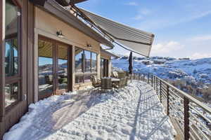 Snow covered patio featuring outdoor dining area